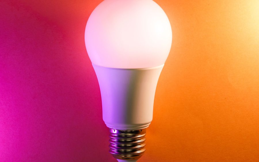Ampoule allumée sur fond coloré, illustration de l'innovation en formulation